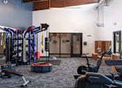 Thumbnail 7 of 28 - a gym with cardio machines and other exercise equipment at The Bosk Apartment Homes, Woodbury, MN