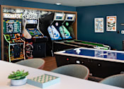 Thumbnail 6 of 28 - a gaming room with arcade games and tables at The Bosk Apartment Homes, Minnesota