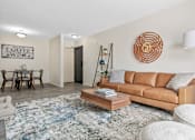 Thumbnail 6 of 31 - Living Room with Brown Couch at The Bosk Apartment Homes, Woodbury, Minnesota
