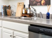 Thumbnail 9 of 28 - a kitchen counter with a sink and a dishwasher at The Bosk Apartment Homes, Woodbury, MN, 55125