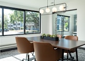 Thumbnail 15 of 28 - a conference room with a large window and a table with chairs at The Bosk Apartment Homes, Woodbury, 55125