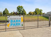 Thumbnail 18 of 29 - A sign welcoming visitors to Bark Park is displayed on a fence.