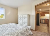 Thumbnail 9 of 29 - A bedroom with a large bed and a dresser with a mirror.