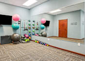 Thumbnail 15 of 29 - A room with exercise equipment and a mirror on the wall.