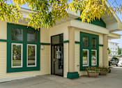Thumbnail 26 of 29 - A small building with a green trim and a black door.