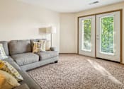 Thumbnail 3 of 29 - A living room with a grey couch and a lamp.