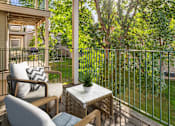 Thumbnail 5 of 29 - A patio with a table and chairs overlooks a green lawn.