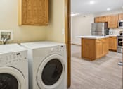 Thumbnail 11 of 29 - Two front load washing machines in a laundry room.