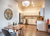 Thumbnail 4 of 24 - Kitchen with White Cabinets and Small Dining Table