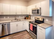 Thumbnail 6 of 24 - Kitchen with Appliances and White Cabinets