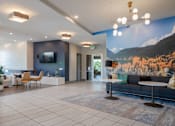 Thumbnail 15 of 29 - a lobby with a couch table and chairs and a large mural on the wall