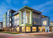 Thumbnail 29 of 29 - Exterior image of Westend Apartments building lit up at night time.