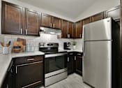 Thumbnail 2 of 18 - Kitchen with Wood Cabinets and Stainless Steel Fridge