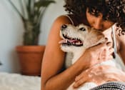 Thumbnail 3 of 23 - a woman hugging her dog on a bed