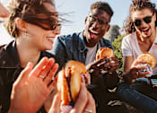 Thumbnail 11 of 24 - a group of people eating hot dogs    and laughing