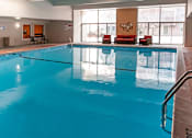 Thumbnail 13 of 24 - a large indoor pool with chairs and a couch next to it