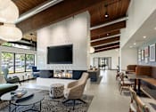 Thumbnail 19 of 28 - A modern living room with a fireplace and a television at The Bosk Apartment Homes, Woodbury, 55125