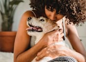 Thumbnail 8 of 28 - a woman kissing a dog on a bed at The Bosk Apartment Homes, Woodbury, 55125