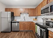 Thumbnail 5 of 29 - A kitchen with wooden cabinets and a black stove top oven.