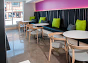 Thumbnail 12 of 18 - a seating area with tables and chairs