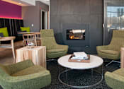 Thumbnail 10 of 18 - a living room with green chairs and a fireplace