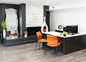 Thumbnail 10 of 32 - an office space with a desk and orange chairs at La Bella Apartments, Fort Worth, TX, 76116