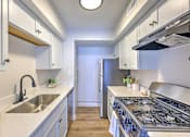 Thumbnail 15 of 29 - A kitchen with a stove, sink, and refrigerator.