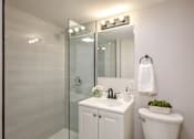 Thumbnail 19 of 29 - A white bathroom with a toilet, sink, and mirror.