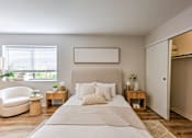 Thumbnail 12 of 29 - A bedroom with a large bed, a chair, and a painting on the wall.