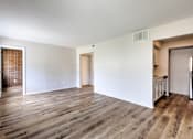 Thumbnail 23 of 29 - A room with wooden flooring and white walls.