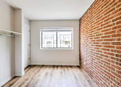 Thumbnail 26 of 29 - A room with a brick wall and a window.