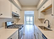 Thumbnail 14 of 29 - A kitchen with white cabinets and a stainless steel sink.