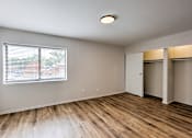Thumbnail 22 of 29 - A room with wooden floors and a window with blinds.