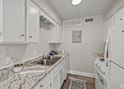 Thumbnail 29 of 32 - A kitchen with white cabinets and appliances. at La Bella Apartments, Fort Worth, TX