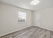 Thumbnail 28 of 32 - A room with a wooden floor and a window with blinds. at La Bella Apartments, Fort Worth, 76116