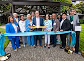 Thumbnail 54 of 57 - A group of people are gathered around a ribbon cutting ceremony.