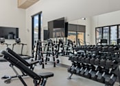Thumbnail 134 of 144 - A gym with a variety of equipment including dumbbells and weight machines.