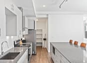 Thumbnail 76 of 131 - A modern kitchen with a sink, stove, and refrigerator.