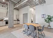 Thumbnail 83 of 131 - A dining area with a table surrounded by grey chairs.