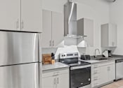 Thumbnail 78 of 131 - A modern kitchen with stainless steel appliances and white cabinets.