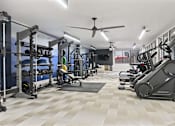 Thumbnail 8 of 55 - A gym with a variety of equipment including a treadmill, weights, and a bench press.