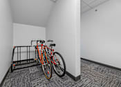 Thumbnail 50 of 74 - a bike rack in a white room with two bikes on it at Red Rock Apartments, Rapid City, South Dakota