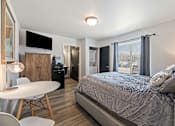 Thumbnail 71 of 74 - a bedroom with a bed and a small white table and chairs at Red Rock Apartments, Rapid City, South Dakota