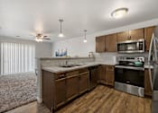 Thumbnail 56 of 74 - a kitchen with wooden cabinets and stainless steel appliances at Red Rock Apartments, Rapid City, SD