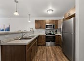 Thumbnail 53 of 74 - a kitchen with stainless steel appliances and wooden cabinets at Red Rock Apartments, Rapid City, 57702