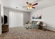 Thumbnail 59 of 74 - a living room with a couch and a ceiling fan at Red Rock Apartments, Rapid City, SD