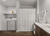 Thumbnail 74 of 74 - a washer and dryer in a bathroom with a shower and a sink at Red Rock Apartments, South Dakota
