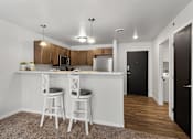 Thumbnail 52 of 74 - a kitchen with a bar and two stools in front of a counter top at Red Rock Apartments, Rapid City