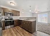 Thumbnail 57 of 74 - a kitchen with wooden cabinets and stainless steel appliances at Red Rock Apartments, South Dakota