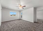 Thumbnail 63 of 74 - an empty living room with carpet and a ceiling fan at Red Rock Apartments, Rapid City, SD